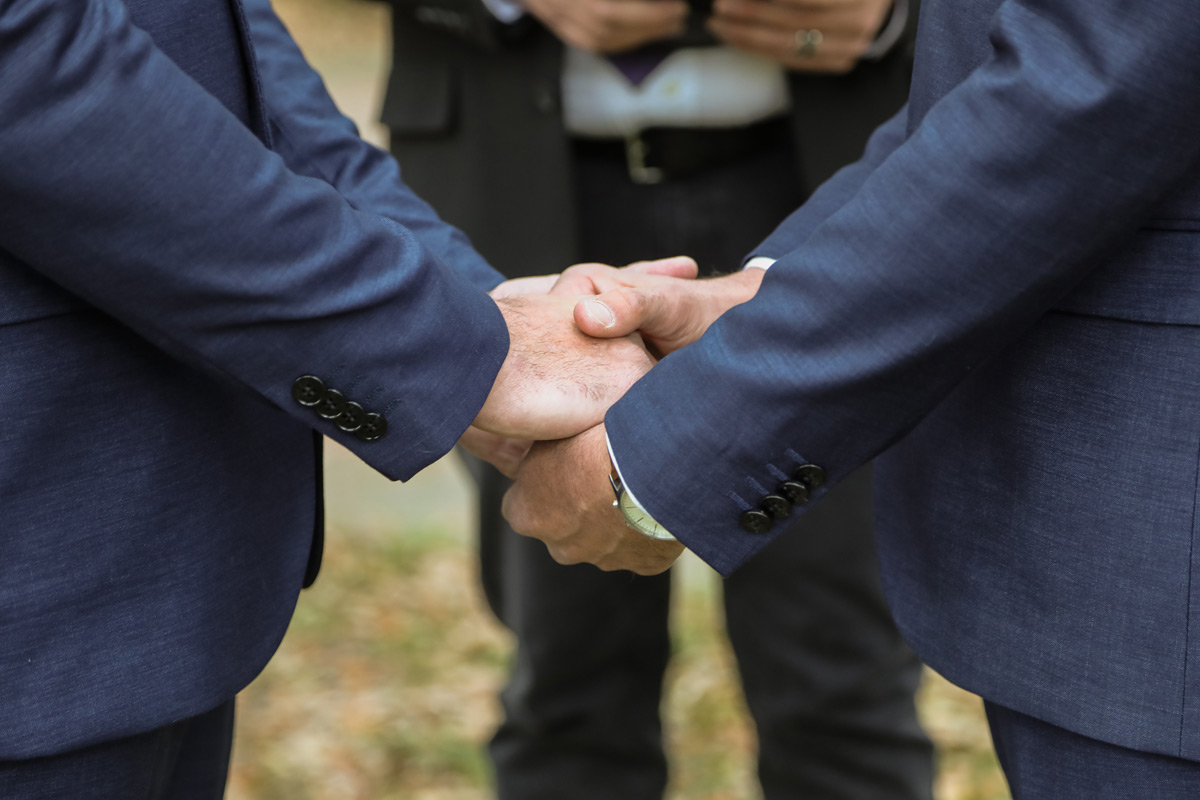 Two men in love holding hands during their ceremony in Pulaski Square